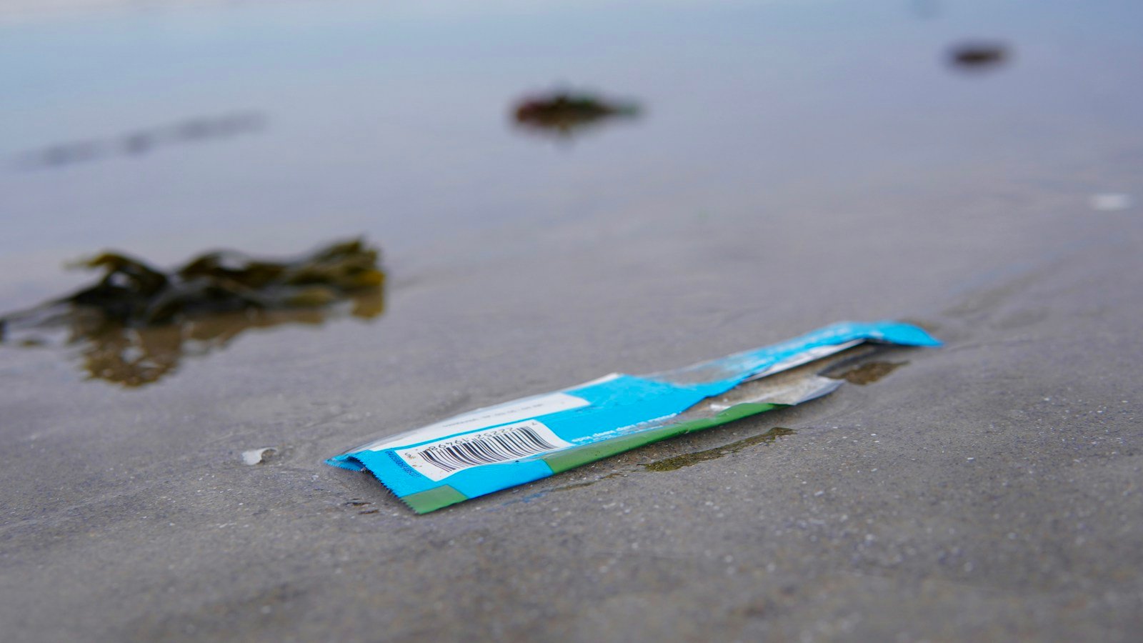 Sampah plastik yang mengotori aliran sungai dan tepian tanah di kawasan permukiman